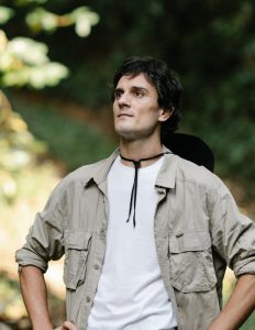 Contemplative man standing in verdant sunny park
