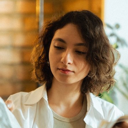 a woman sitting on a couch reading a newspaper